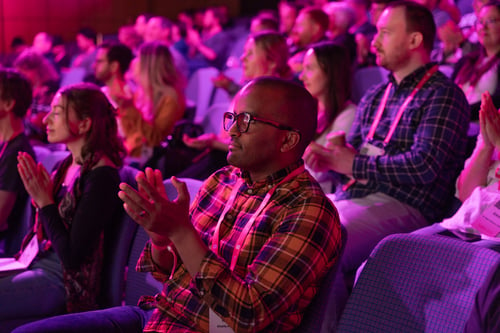 Ahmed Khalifa at a conference, clapping at a speaker.